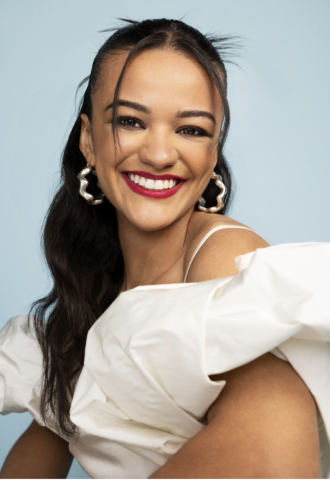 Photo of a woman with brown skin and dark hair wearing a puffy white dress