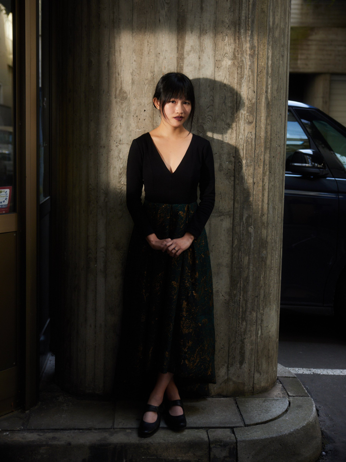 A photo of R. F. Kuang, an Asian woman with dark hair in an updo wearing a black dress